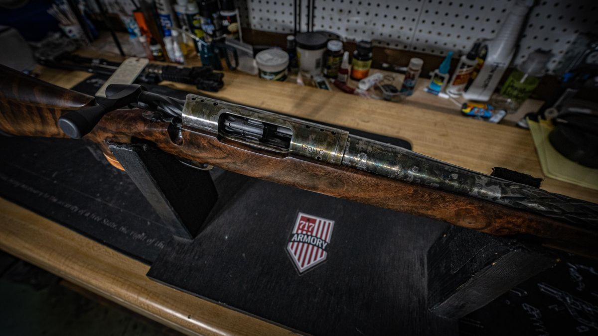 Custom walnut-stock rifle on a 717 Armory display stand