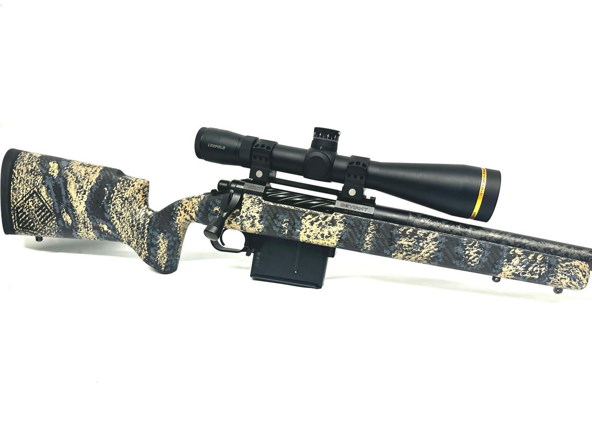 Custom rifle with a gold and black carbon-fiber stock and a long-range scope